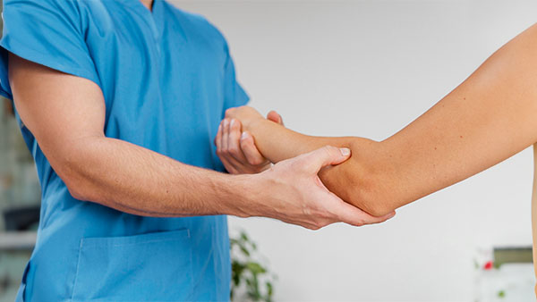 Provider examining patient arm joints for symptoms