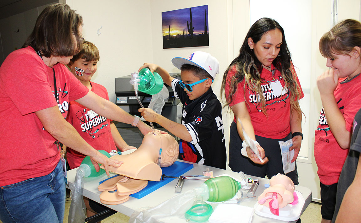 Participants of Super Hero Academy try intubating a manikin