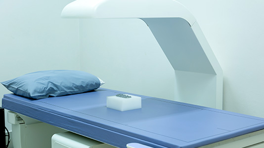 A low dose x-ray machine bed with a slim imaging arm coming over the top. 