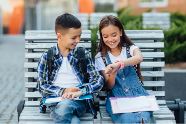 Children sitting on a bench smiling